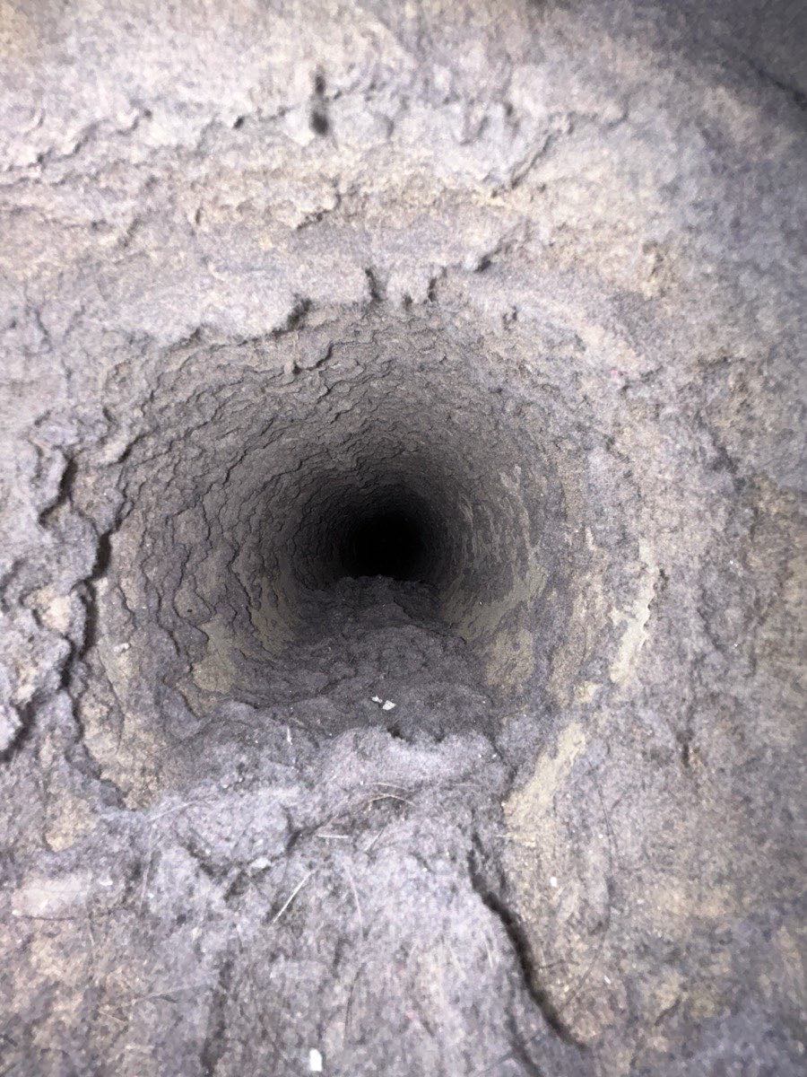 Looking down a dryer duct run fully lined with lint